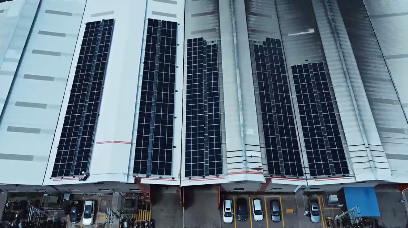 Vista aérea de naves industriales con filas de paneles solares en sus cubiertas